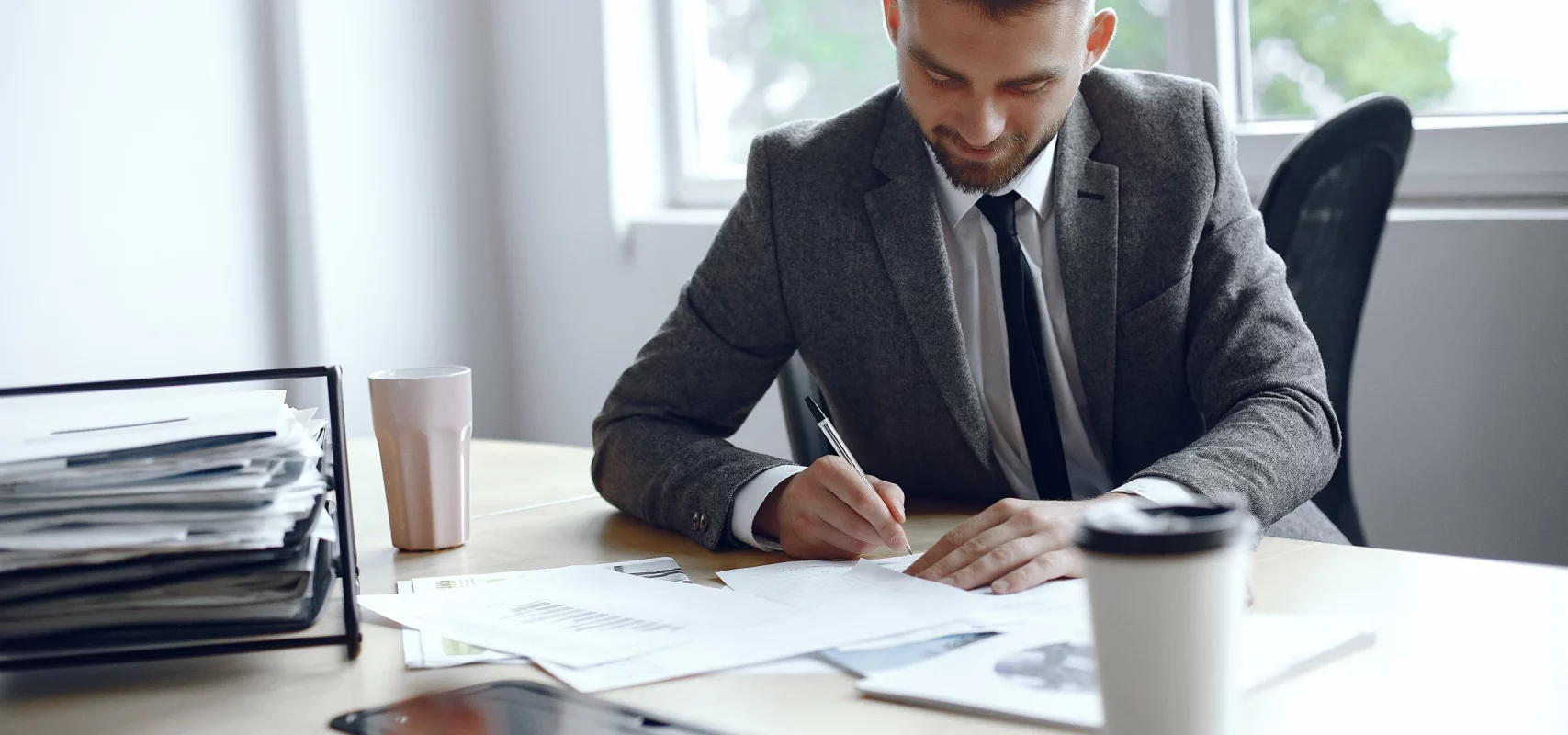 Professionnel en costume signant des documents juridiques au bureau